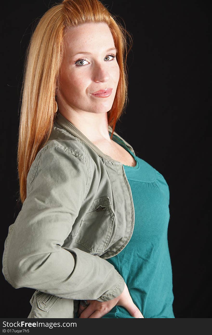 Woman posing with her arms on side with open jacket exposing her front area. Woman posing with her arms on side with open jacket exposing her front area.