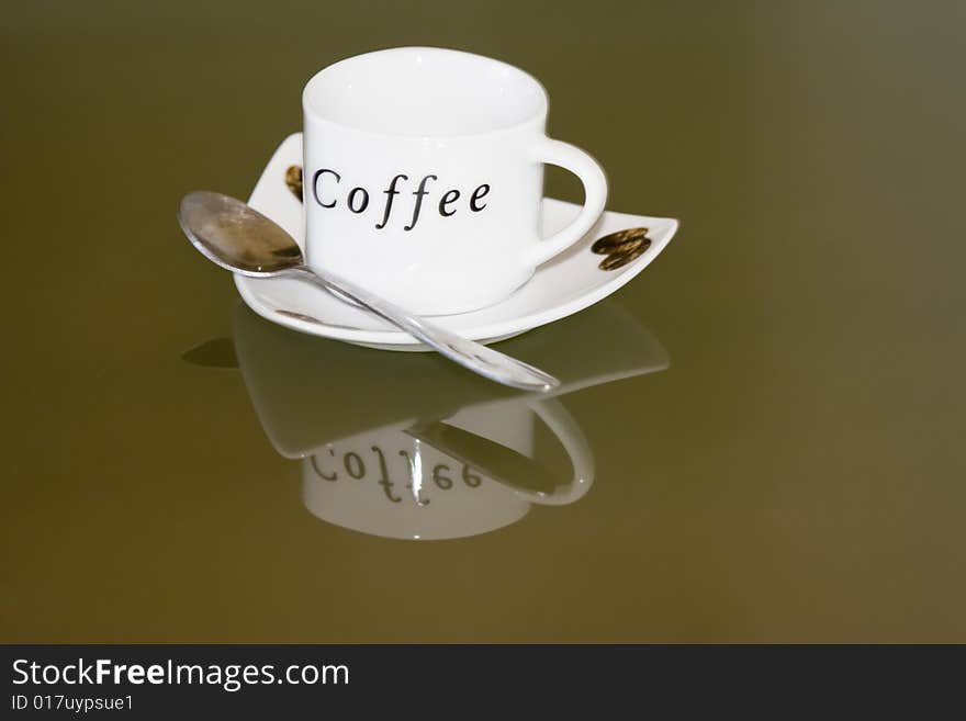 White cup of coffee an reflection in glass table