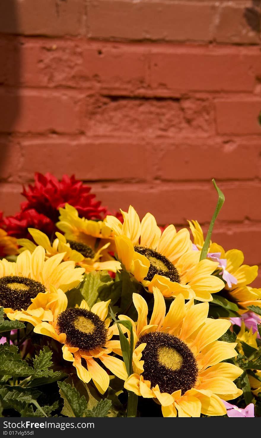 A spring bouquet with sunflowers in front of a brick wall. A spring bouquet with sunflowers in front of a brick wall