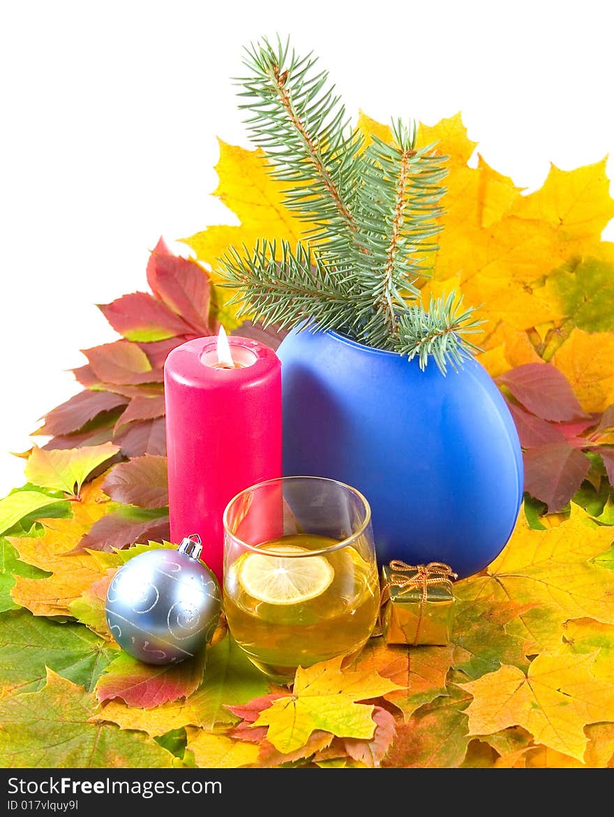 Autumn cognac with lemon Christmas leaves wild grapes and maple burning red candle and christmas-tree decorations on white background. Autumn cognac with lemon Christmas leaves wild grapes and maple burning red candle and christmas-tree decorations on white background