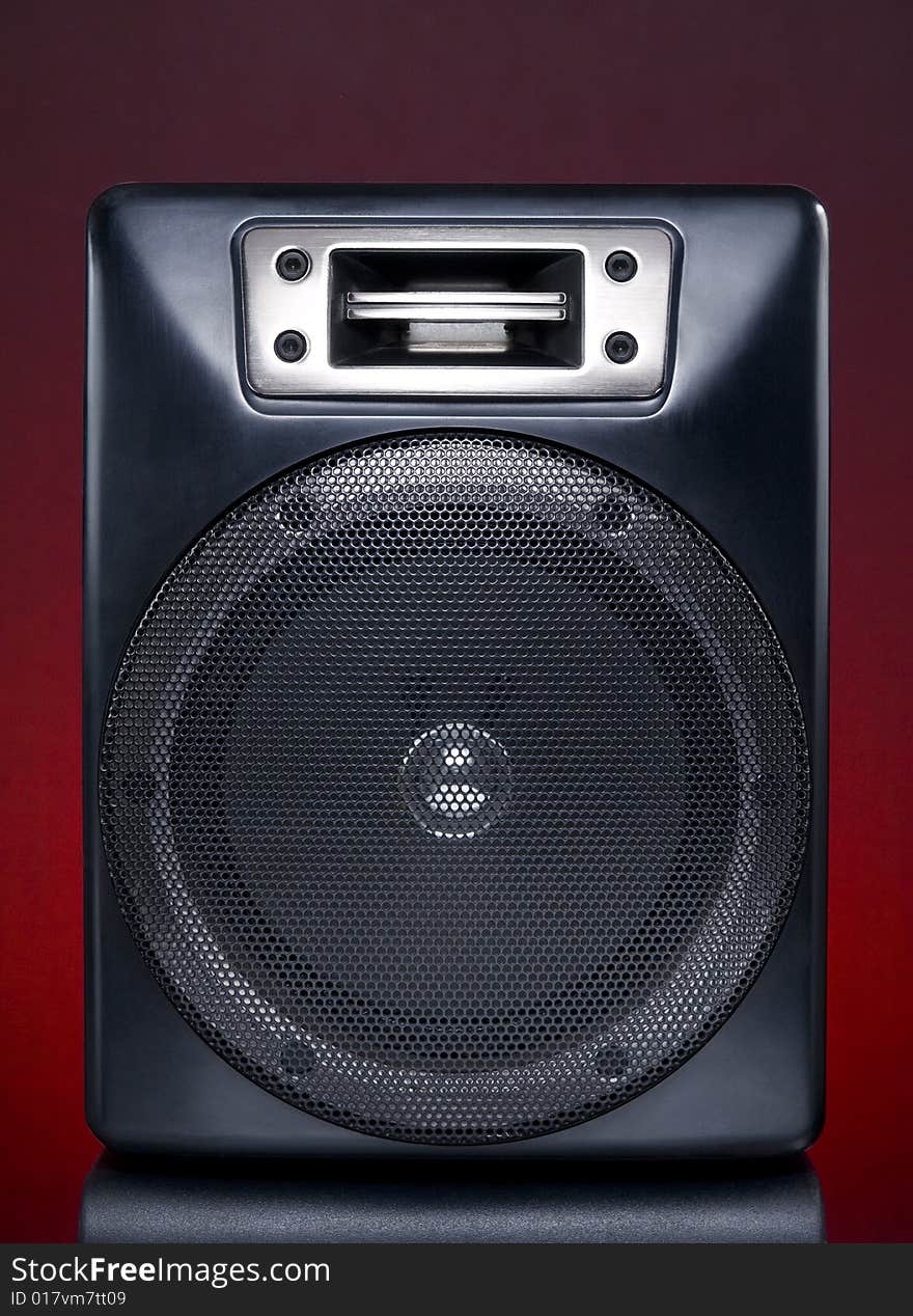 A black speaker over a red background.