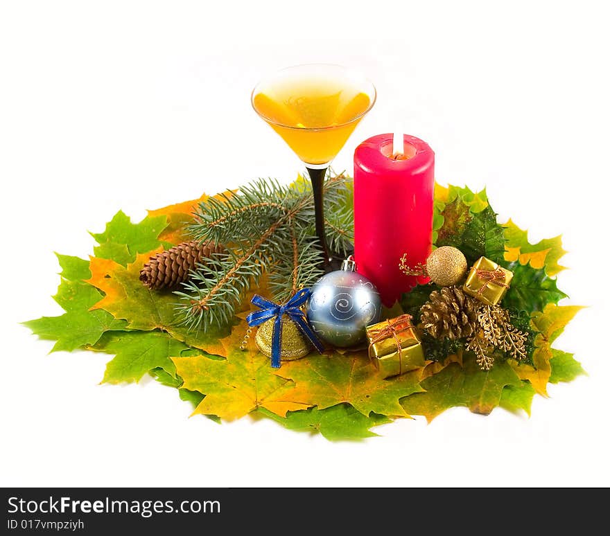 Carpet from autumn maple leaves with wine-glass dessert easy fault and red candle with New Year's decorations on white background. Carpet from autumn maple leaves with wine-glass dessert easy fault and red candle with New Year's decorations on white background