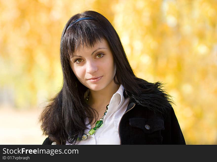 Young beautiful woman in the park over yellow autamn background. Young beautiful woman in the park over yellow autamn background