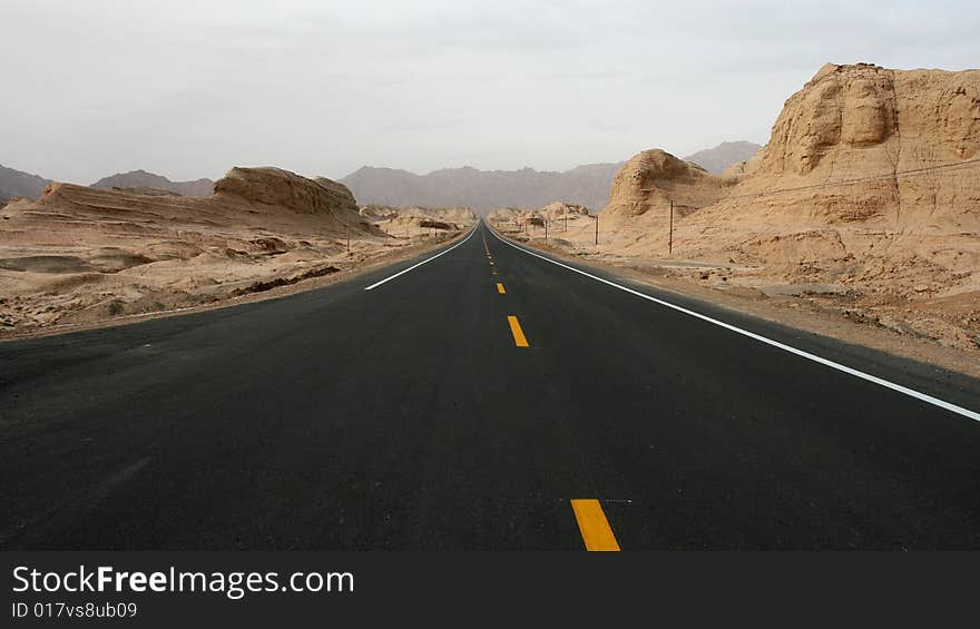 A long straight road with mountain on both sides, taken from Xinjiang, China. A long straight road with mountain on both sides, taken from Xinjiang, China