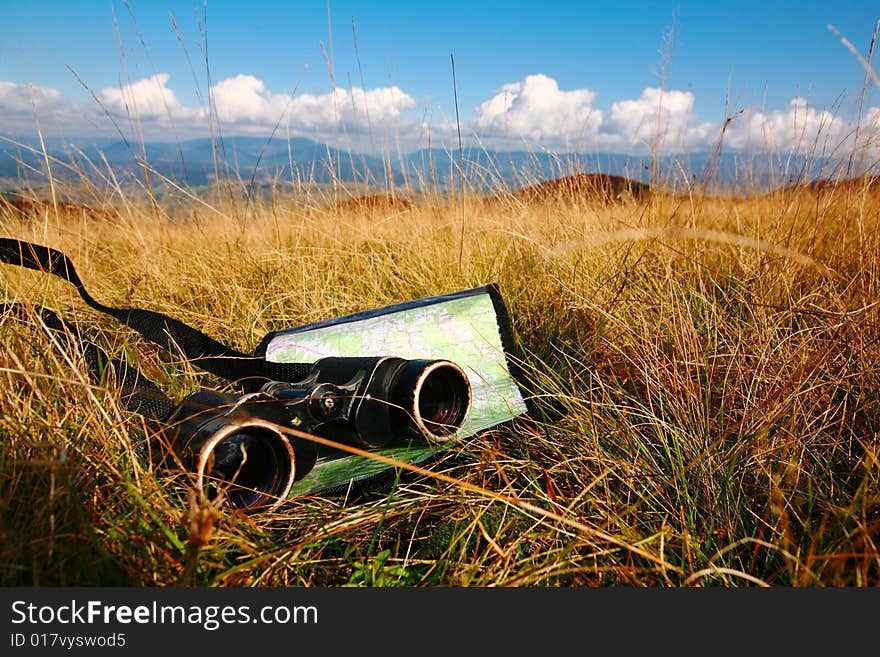 An image of binoculars and map on grass. An image of binoculars and map on grass