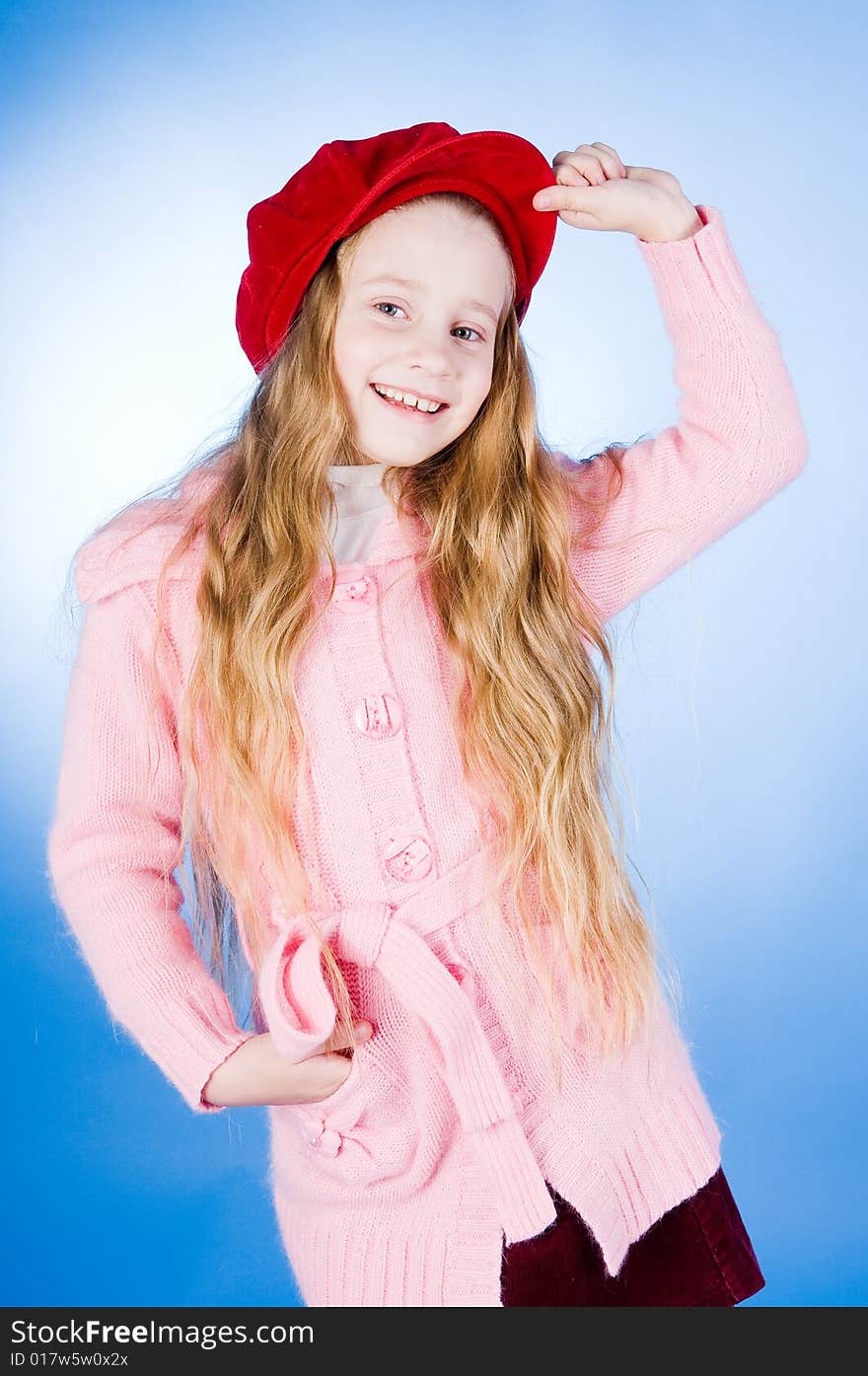 Smiling little girl in red cap, studio shot