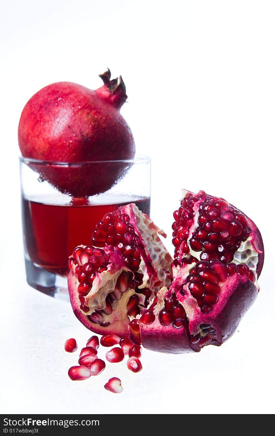 Pomegranate fruits and juice, isolated on white background