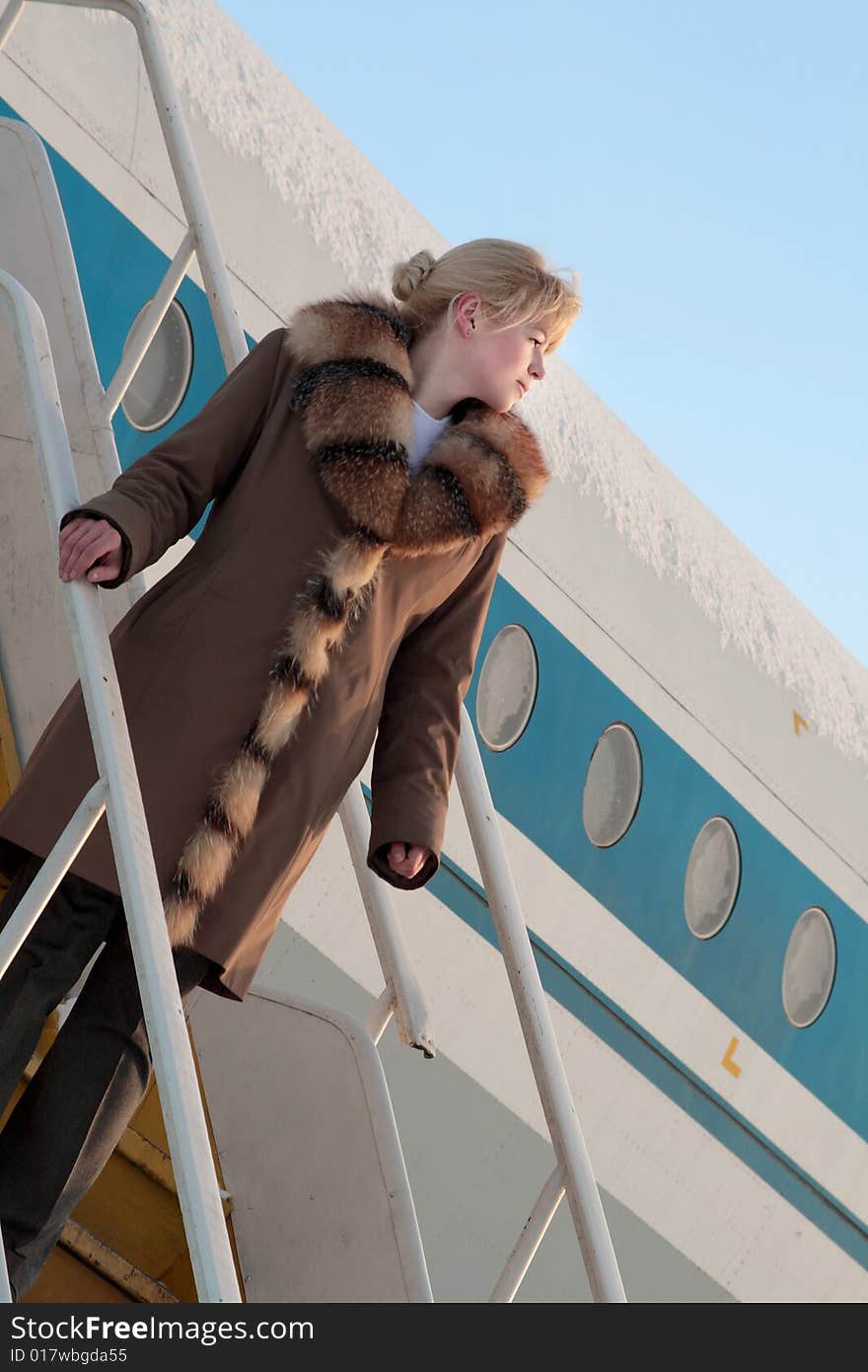 Beautiful flight attendant standing on the airstairs. Beautiful flight attendant standing on the airstairs