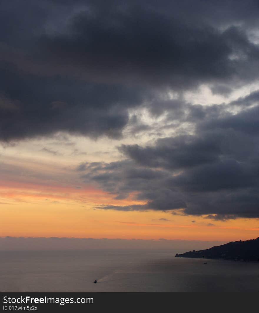 Sunset with large rain clouds above a sea