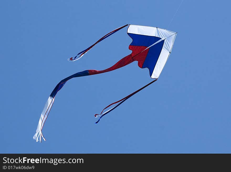 Kite coloured like Russian flag in the blue sky