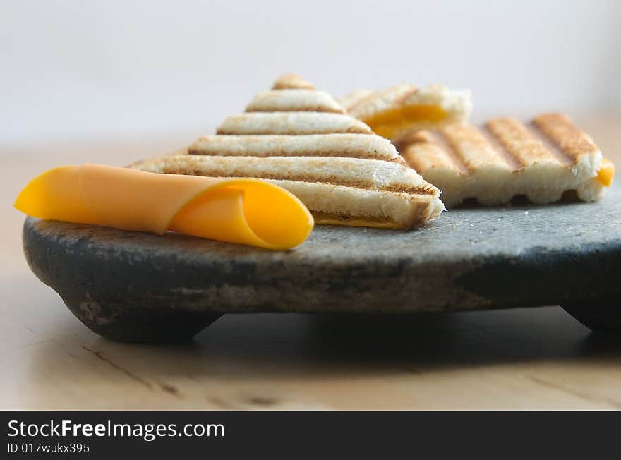 Cheddar cheese tostie on stone plate. Cheddar cheese tostie on stone plate