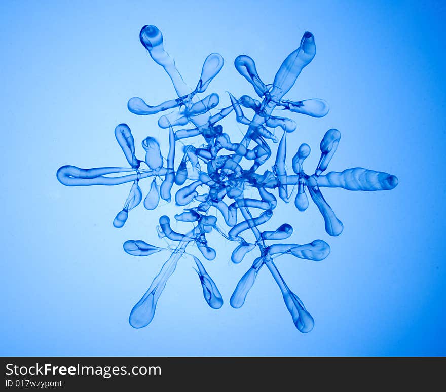 Glass transparent snowflake on blue. Glass transparent snowflake on blue