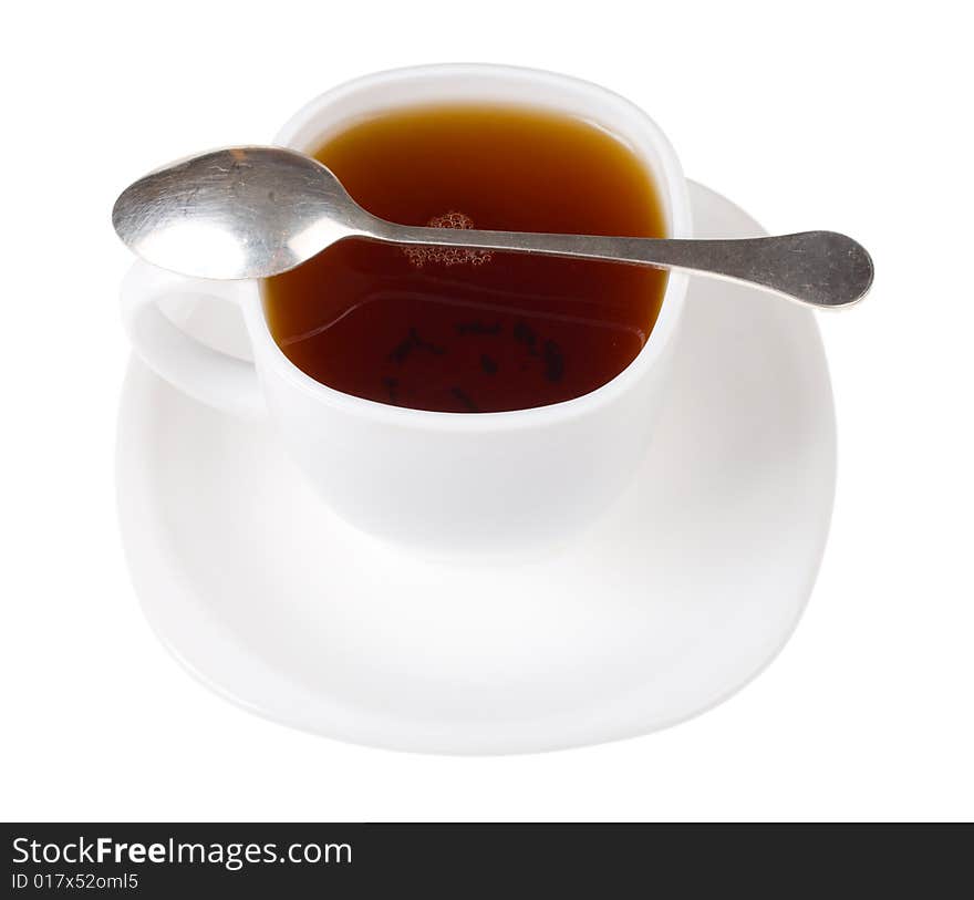 Cup and spoon with black tea, isolated on white