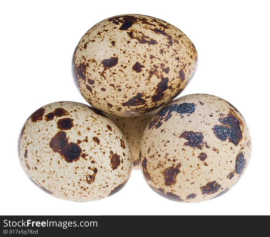 Close-up four quail eggs in pyramid, isolated on white