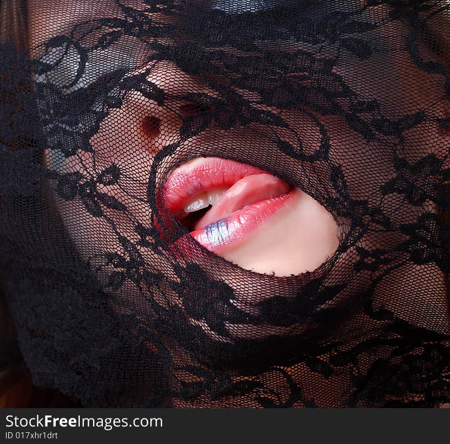 Woman face in a mask of black lace