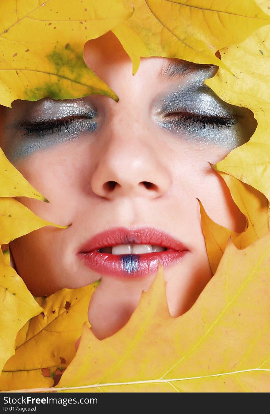 Portrait of a beautiful young woman with maple leaf around her face. Portrait of a beautiful young woman with maple leaf around her face