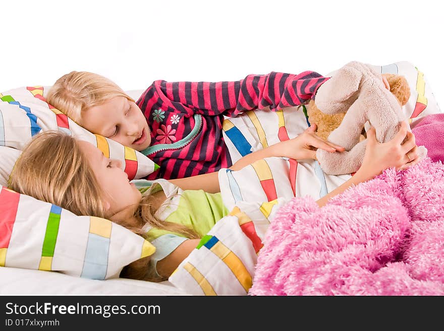 Two young children enjoying their colorful bed. Two young children enjoying their colorful bed