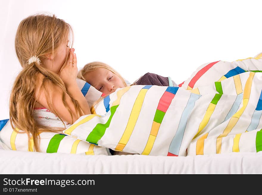 Two young children enjoying their colorful bed. Two young children enjoying their colorful bed