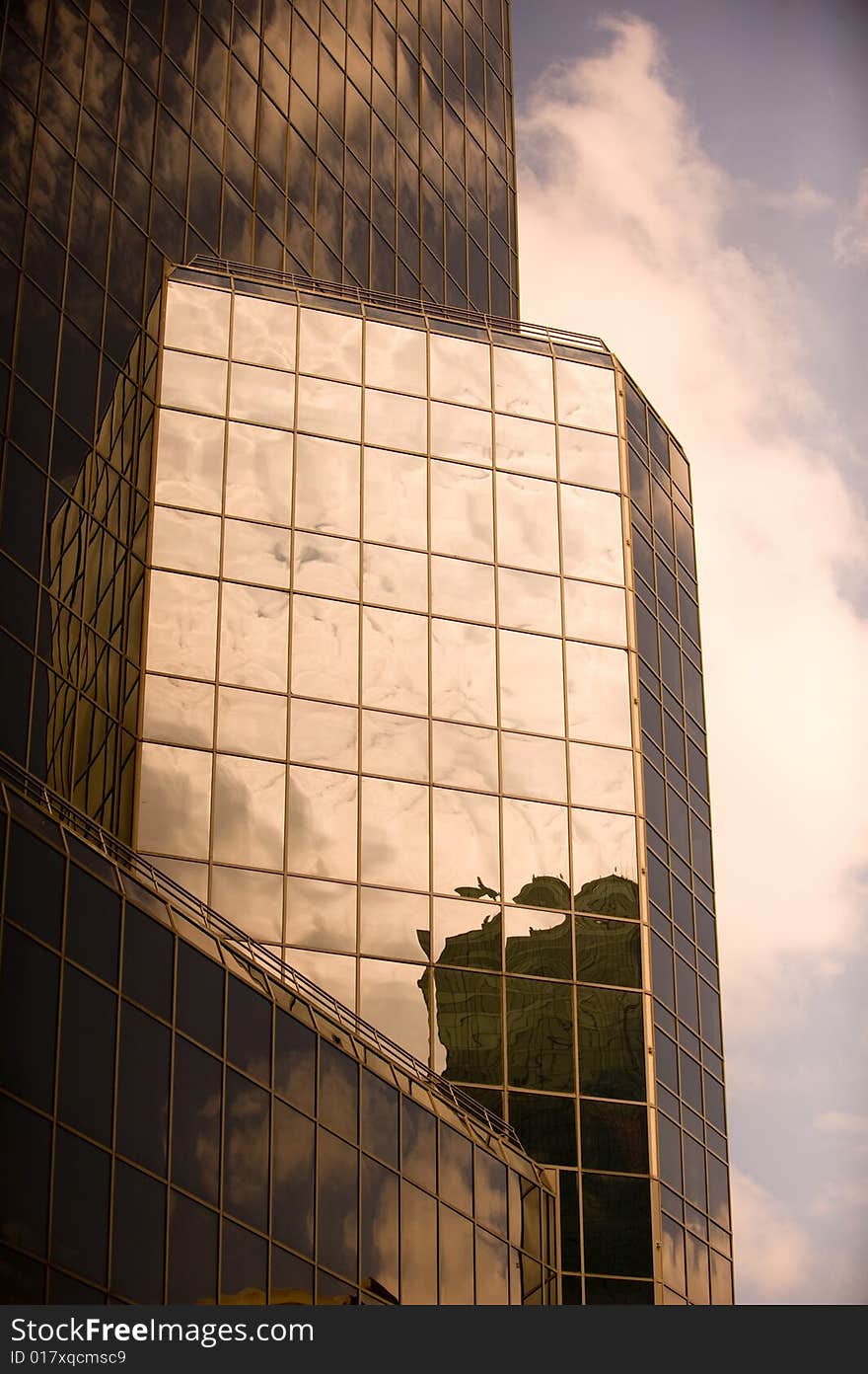 An image of a glass high rise and clouds