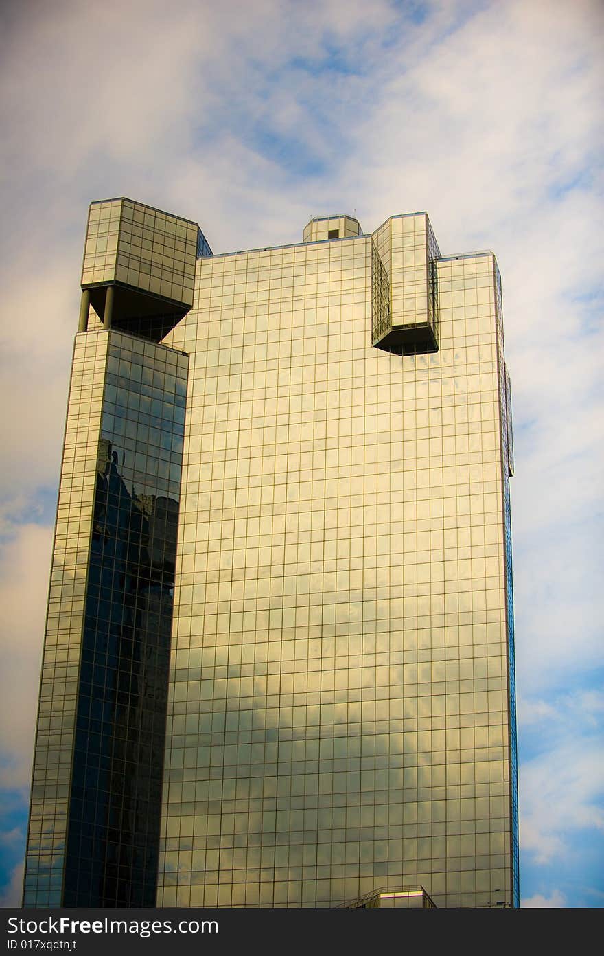 An image of a glass high rise and clouds