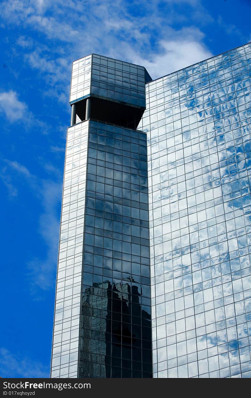 An image of a glass high rise and clouds
