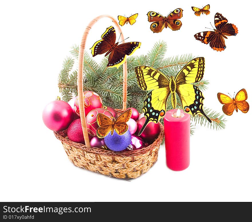 Ornaments from spheres in yellow basket at green branch with butterflies. Ornaments from spheres in yellow basket at green branch with butterflies