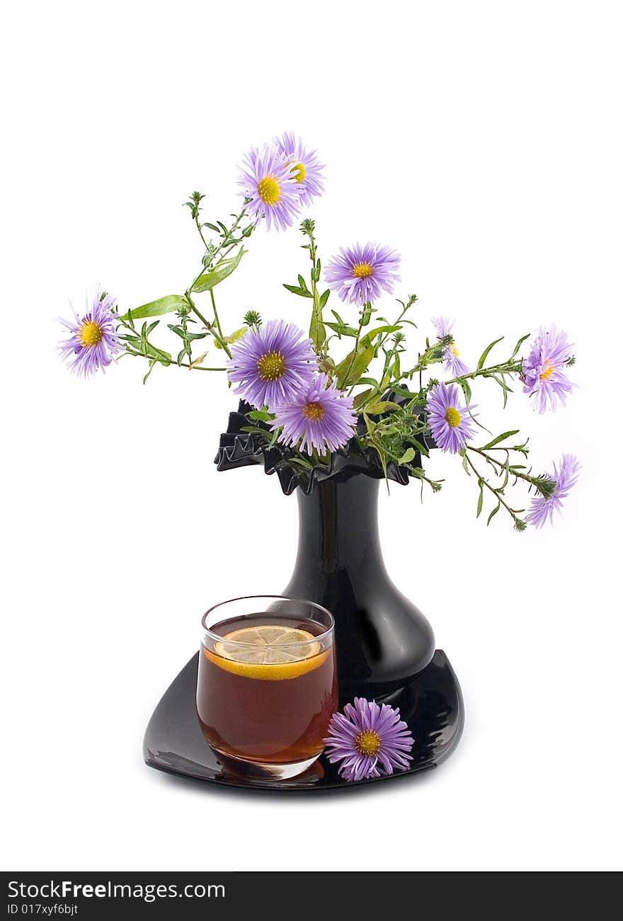 Blue autumn flowers black ceramic beautiful decorative vase and cognac tea lemon white background