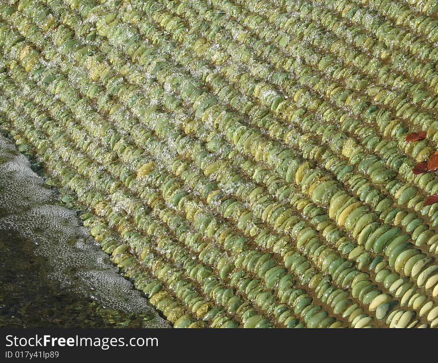 Water on green pebbles fountain