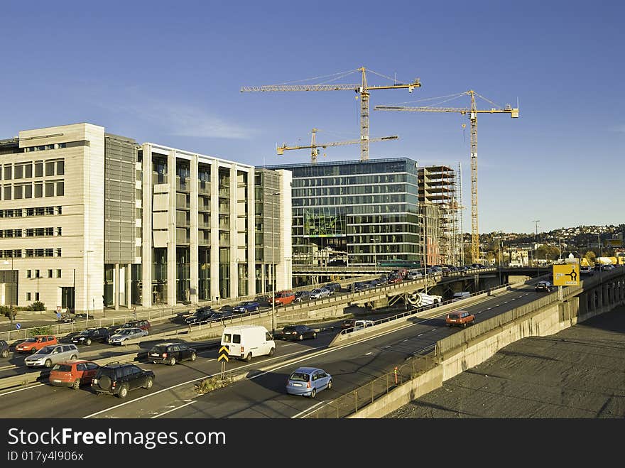 A lot of trafick in the front, and som modern buildings raising up in the background. A lot of trafick in the front, and som modern buildings raising up in the background