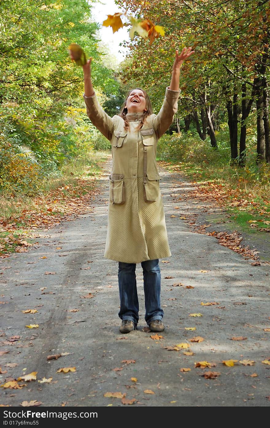 Happy Woman Tosses Up Yellow Leaves