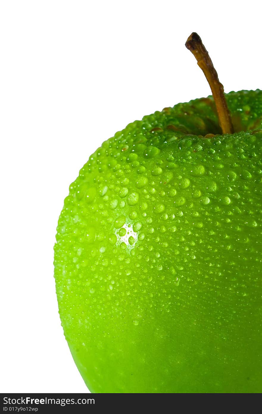 Green apple with multiple water droplets, more concentrated on the top. Freshly washed. Portrait format.