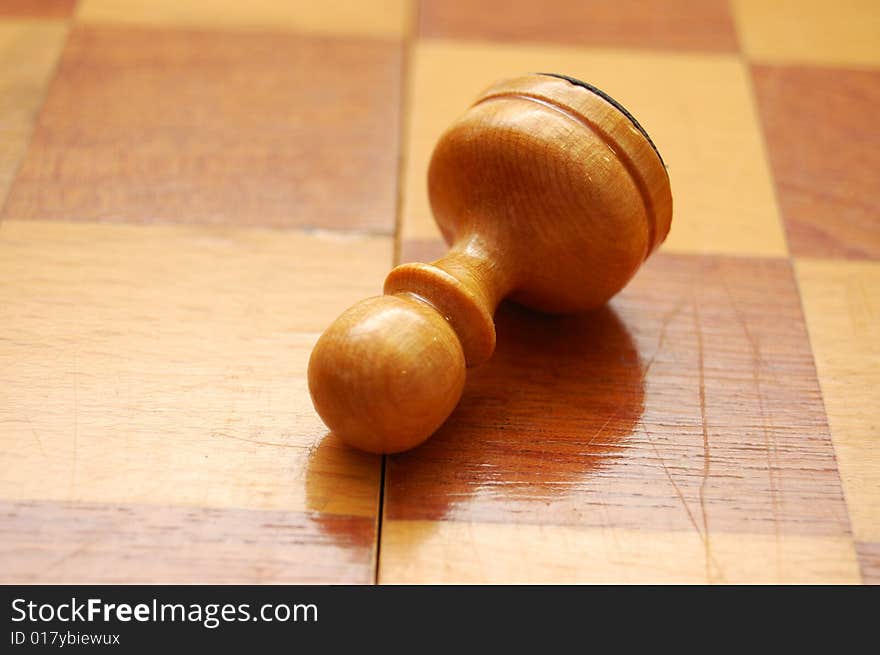 Fallen pawn on chess board