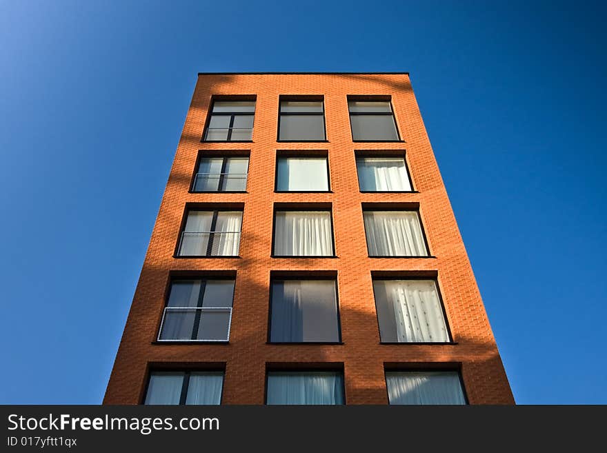 Brick building towering into the blue sky. Brick building towering into the blue sky.