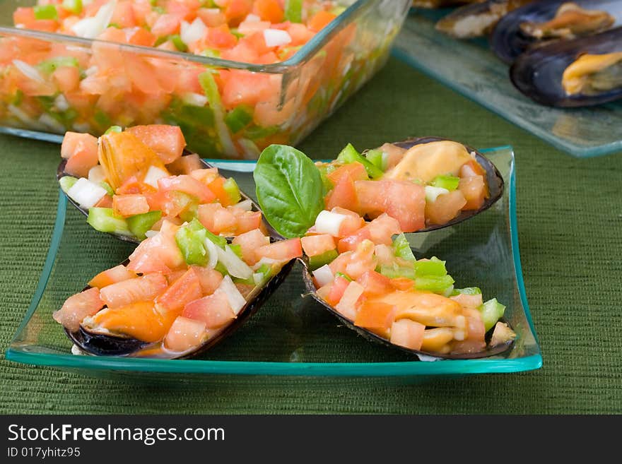 Mussel filled with tomato onions and green pepper on platter