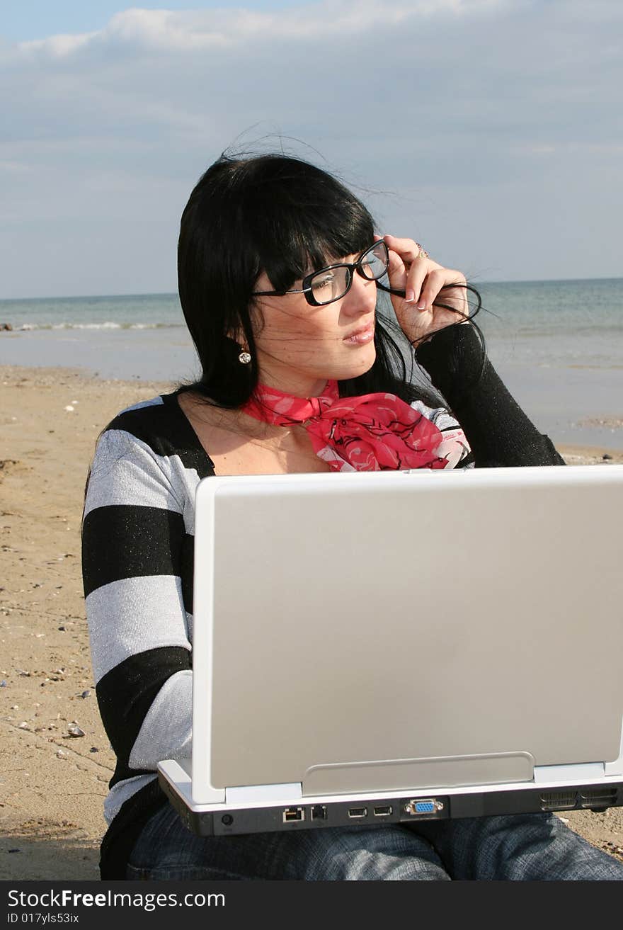 Young woman working with computer at the beach