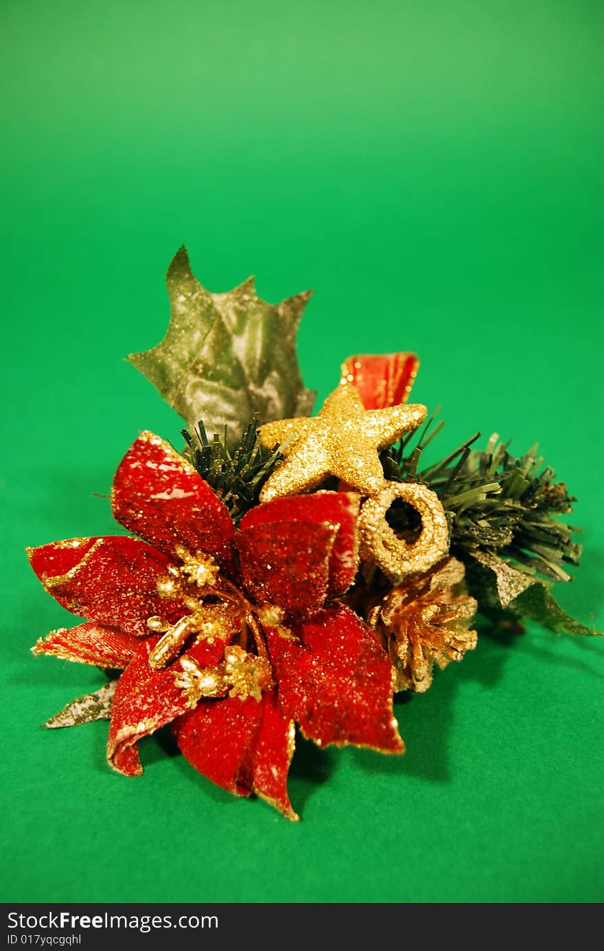 A christmas decoration with a red flower and a golden star on a green background