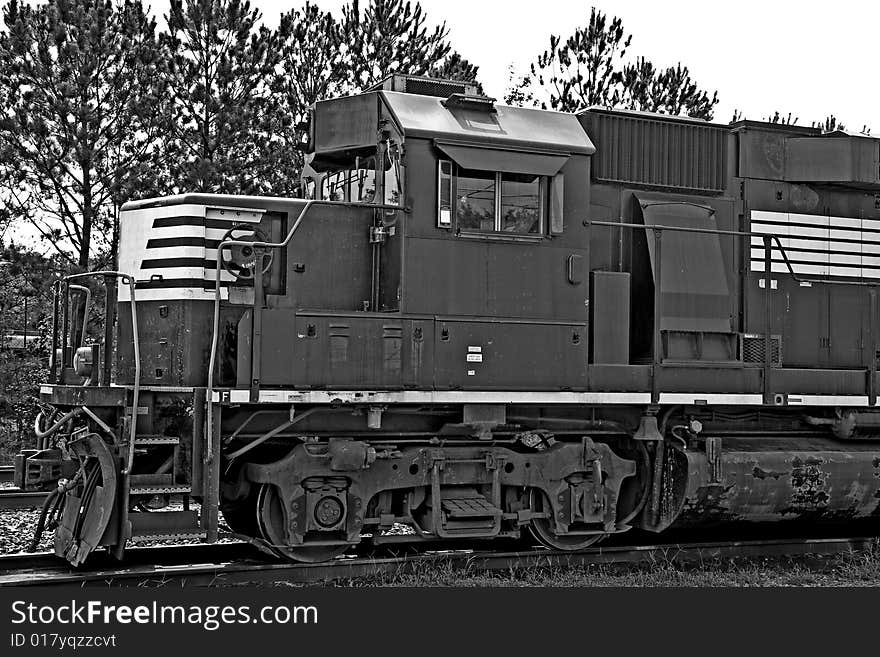 A train engine on a track in black and white. A train engine on a track in black and white