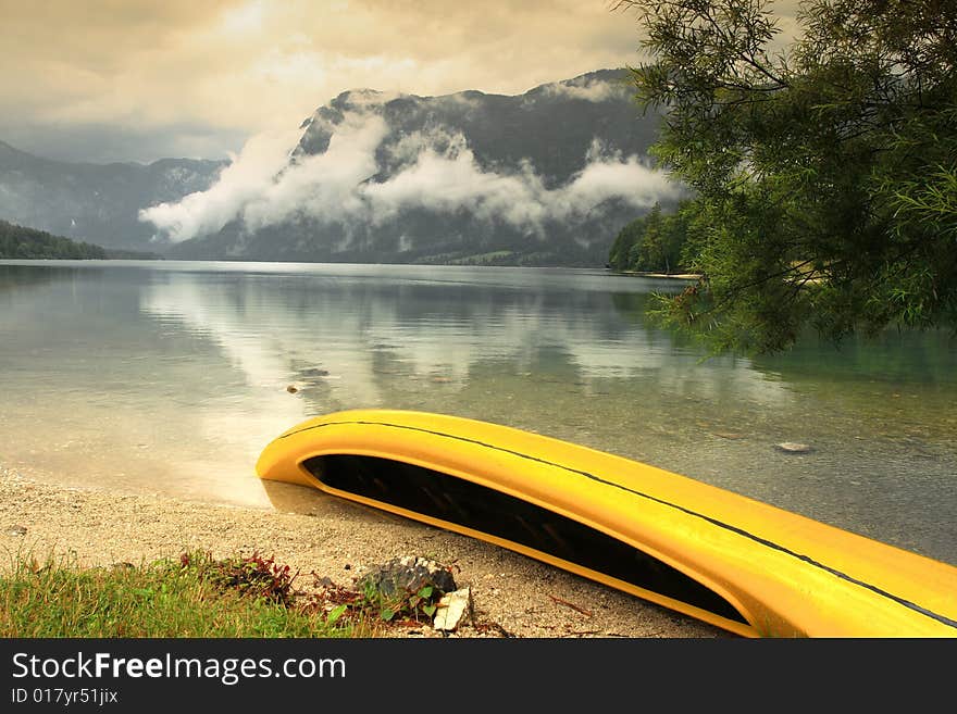 The yellow ship on the bank of Bohinj Lake, Julian Alps, Slovenia. The yellow ship on the bank of Bohinj Lake, Julian Alps, Slovenia