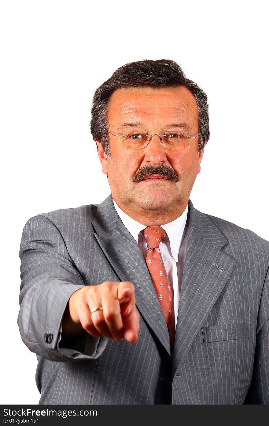 A businessman in his sixties with glasses a suit and a mustache pointing at you Focus on his face. Isolated over white. A businessman in his sixties with glasses a suit and a mustache pointing at you Focus on his face. Isolated over white.