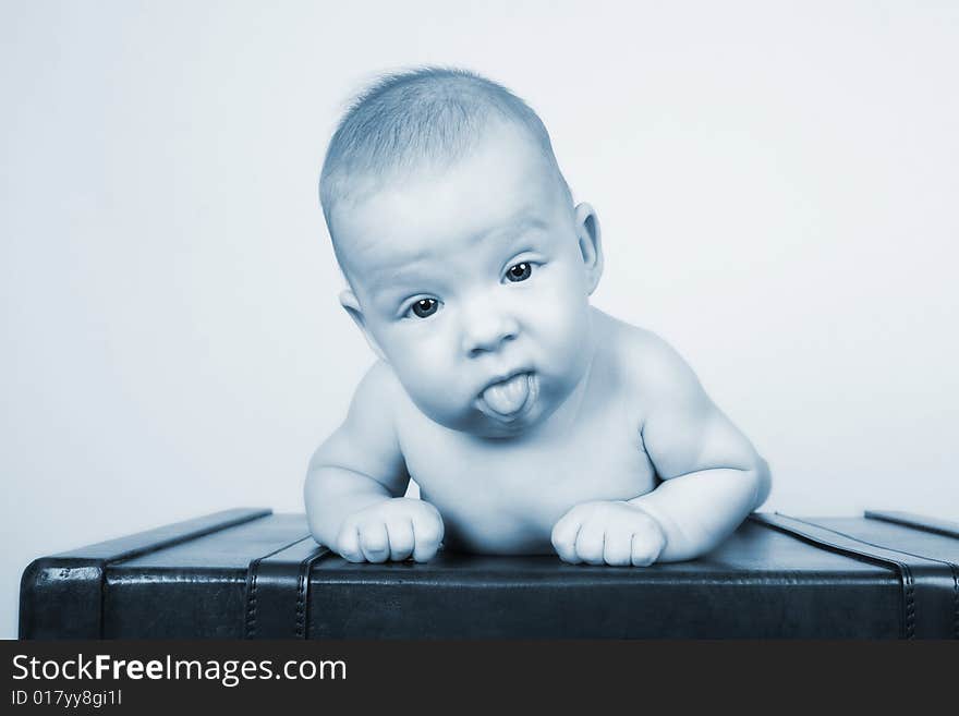 Young baby lying on his tummy on an old style suitcase