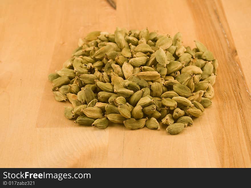 Whole dried cardamom fruits on wood