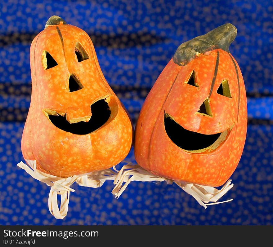 Two funny Halloween pumpkins on glittering blue background. Two funny Halloween pumpkins on glittering blue background