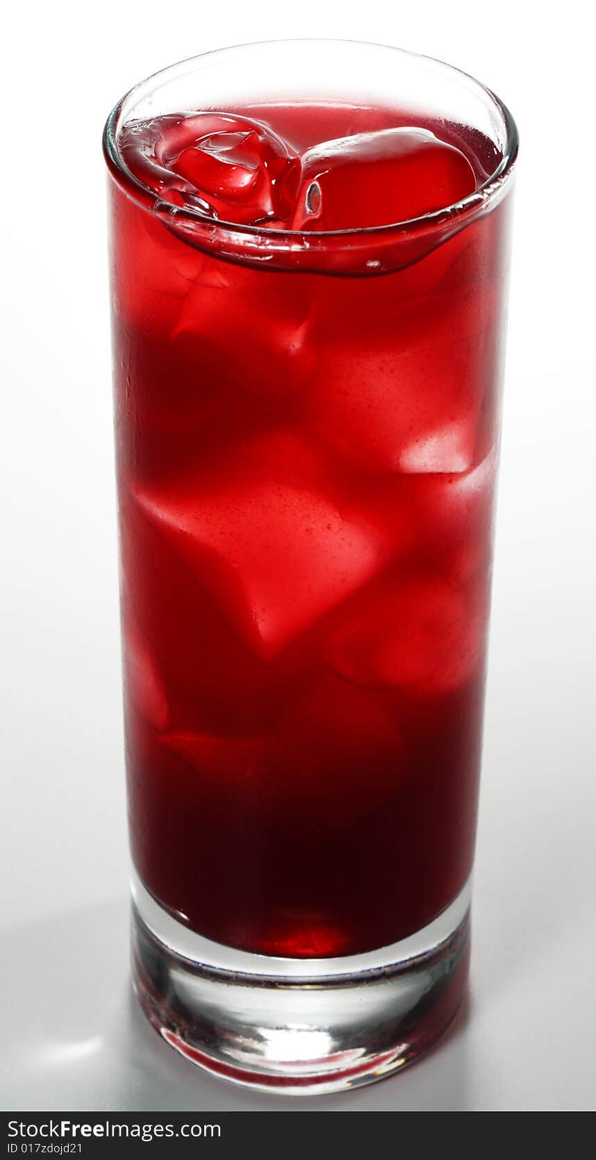 Red Alcoholic Cocktail made of Lychee Liqueur, Pineapple Juice and Cranberries Juice with Ice Cube