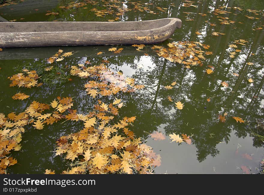 Old wooden shuttle in lake with yellow leaves. Old wooden shuttle in lake with yellow leaves.