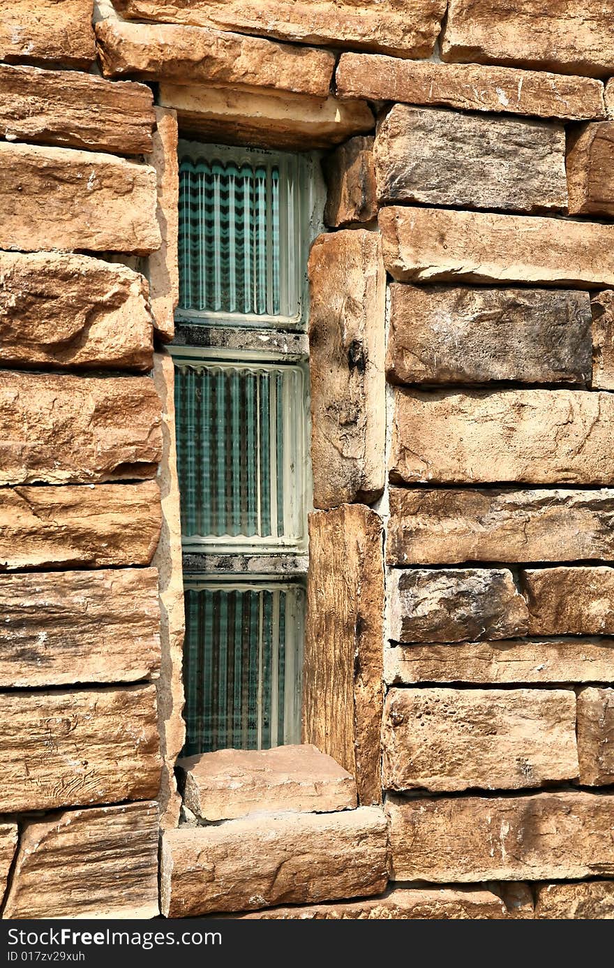 Green Glass Window Framed by Red Orange Brick Stones