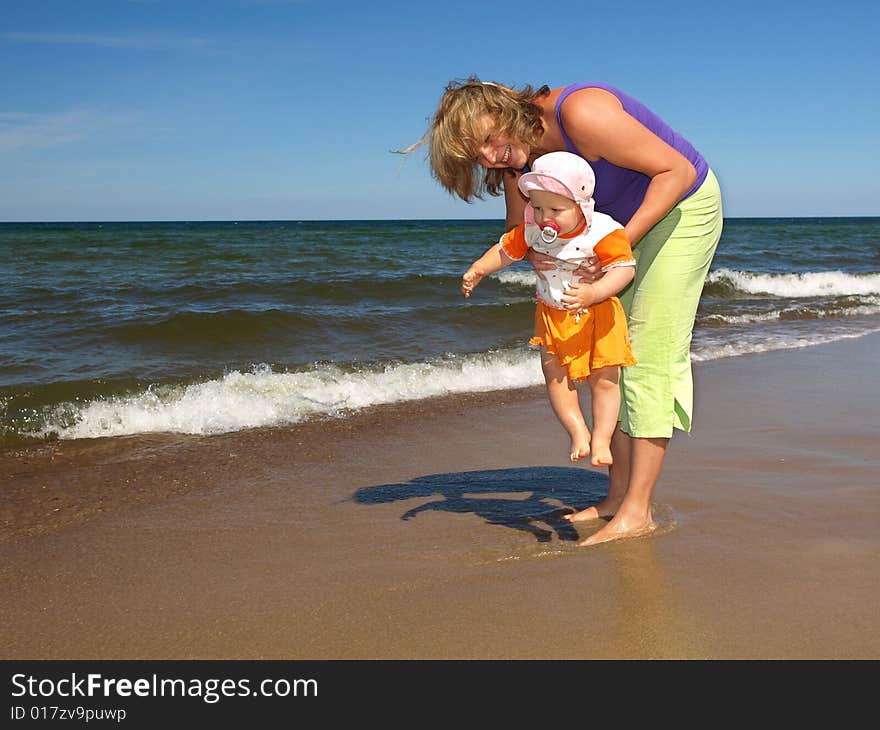 Mother with daughter are playing on the beach. Mother with daughter are playing on the beach