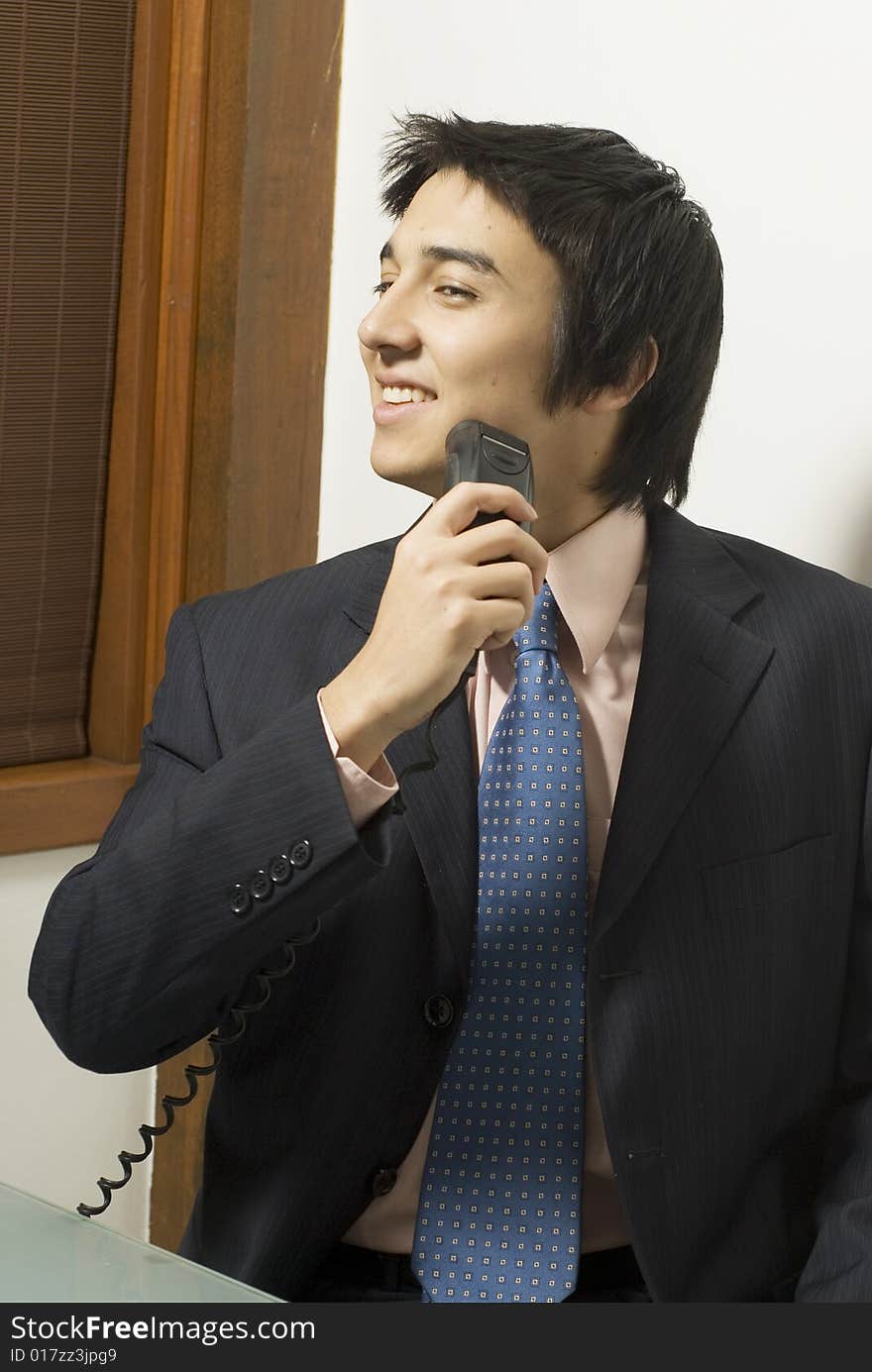 Smiling man in a suit shaving. Vertically framed photo. Smiling man in a suit shaving. Vertically framed photo.