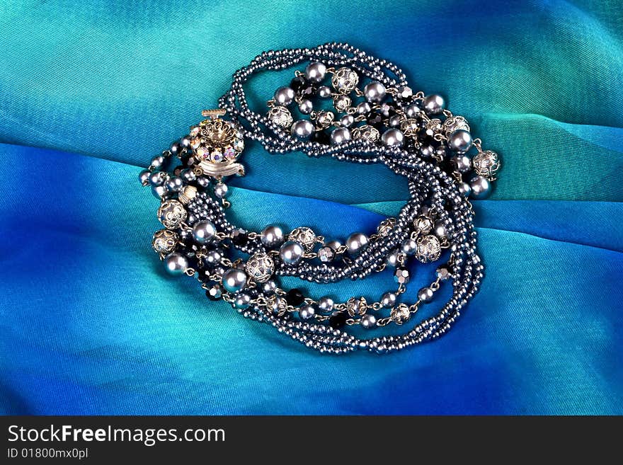 Silver imitation jewelry on light coloured fabric