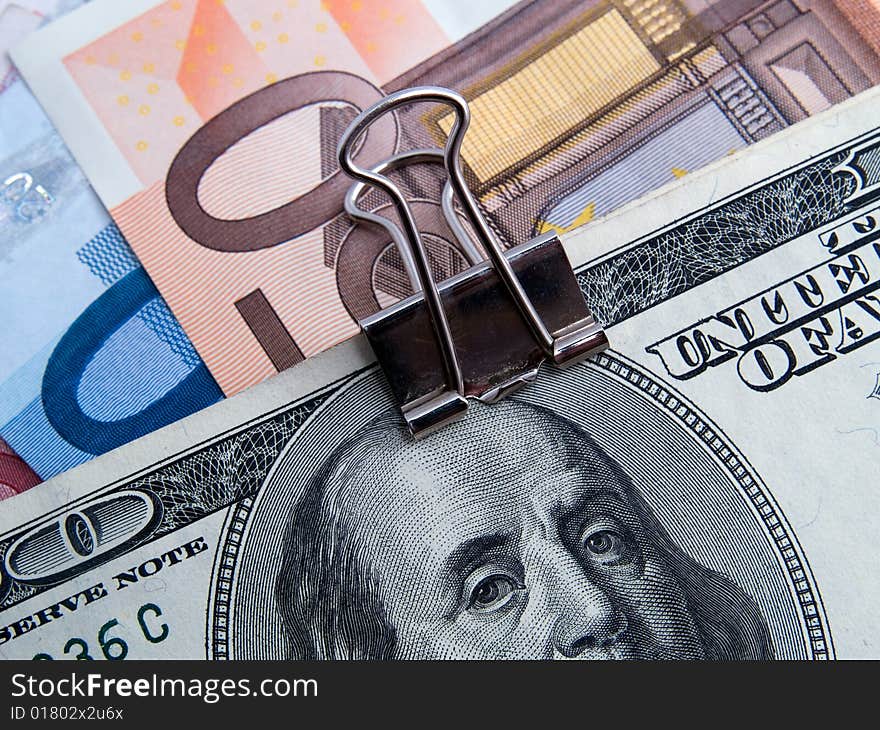 US dollars and euros binded by paper-clip. US dollars and euros binded by paper-clip