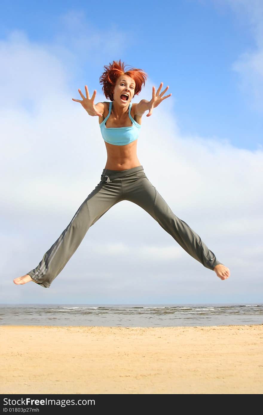 Happy jumping girl on the beach